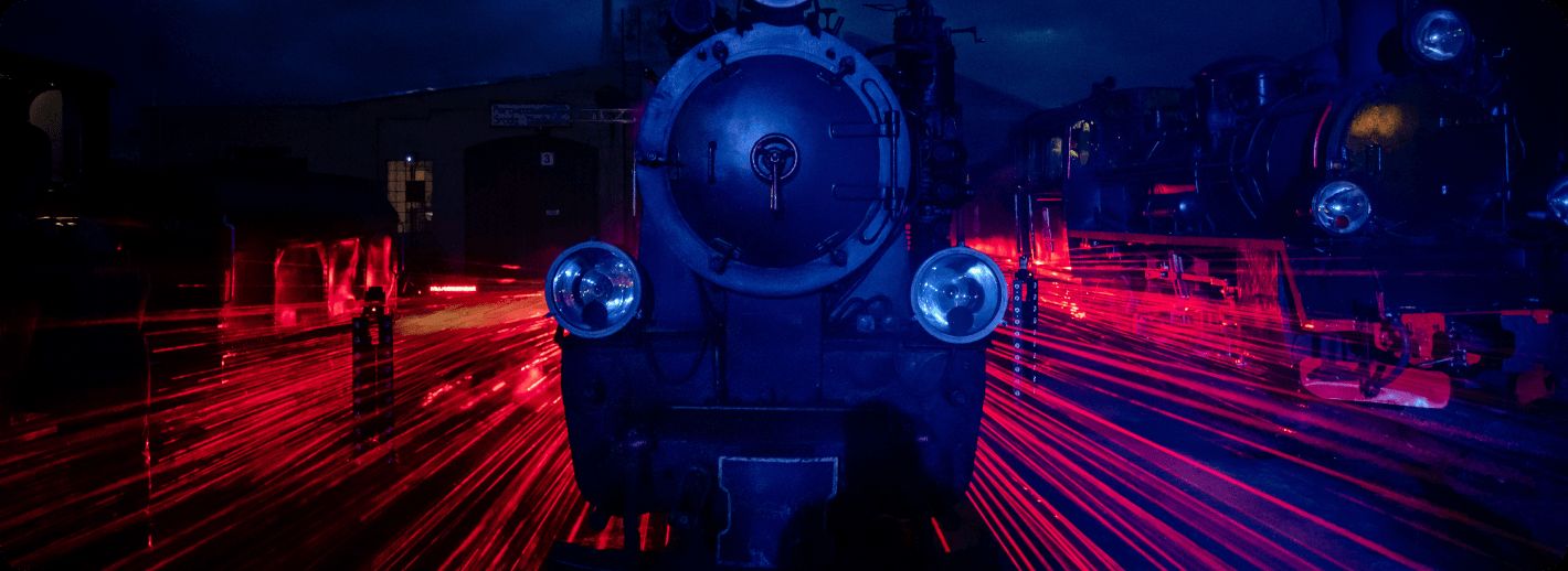 Front lokomotywy nocą. Dookoła jaskrawe światła laserów.